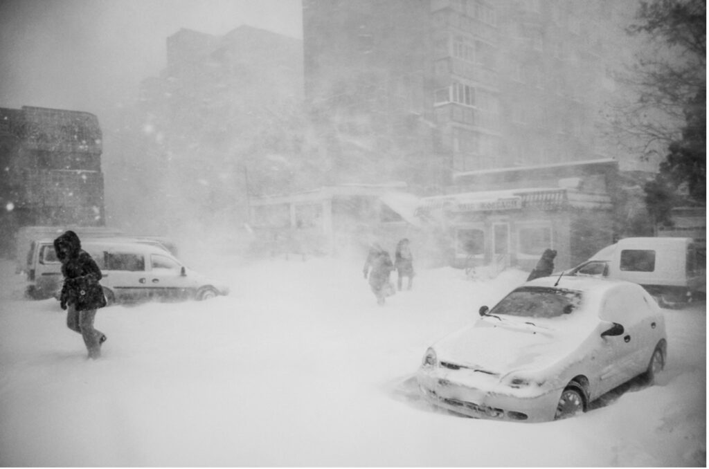 大雪の中で車を降りて避難する人