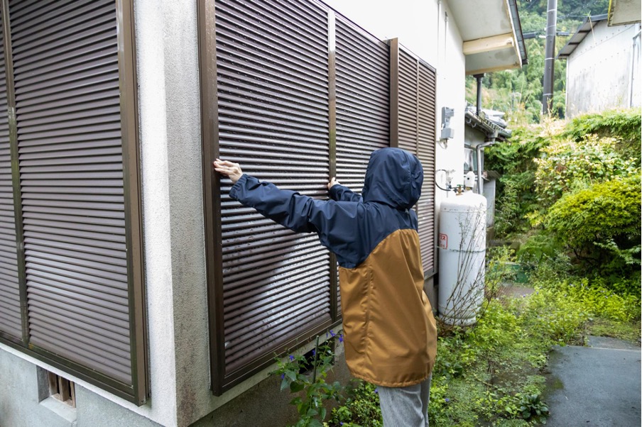 雨戸を閉める人