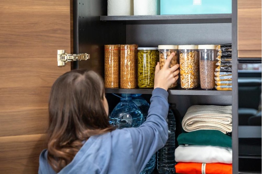 棚から備蓄食料を取り出す女性
