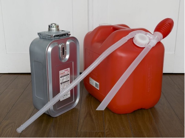 灯油ポンプがかけられたポリタンクと暖房器具のタンク