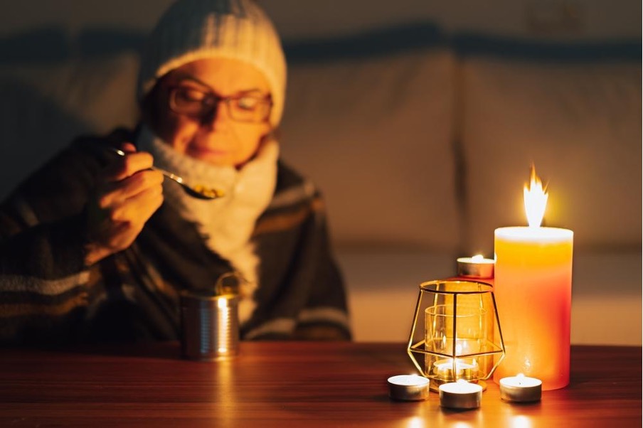 停電の中で缶詰を食べる人
