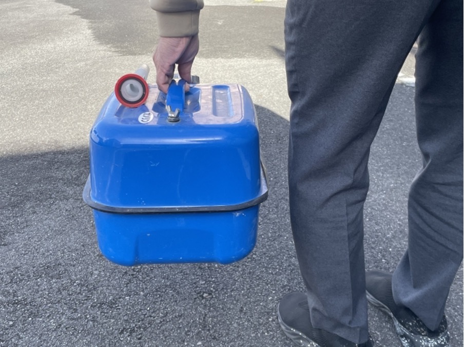 ガソリン携行缶を運ぶ男性